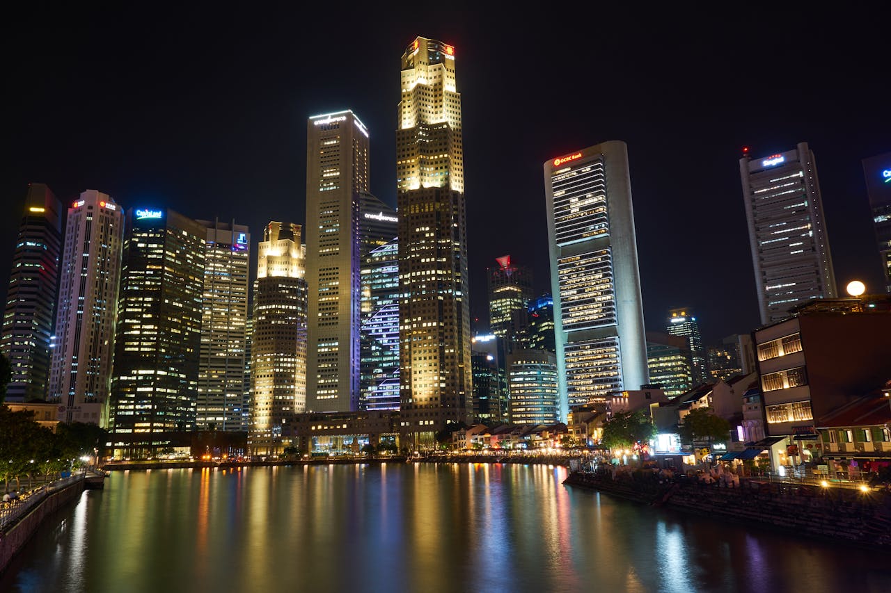 A breathtaking view of Singapore's illuminated skyscrapers reflecting on the river at night.